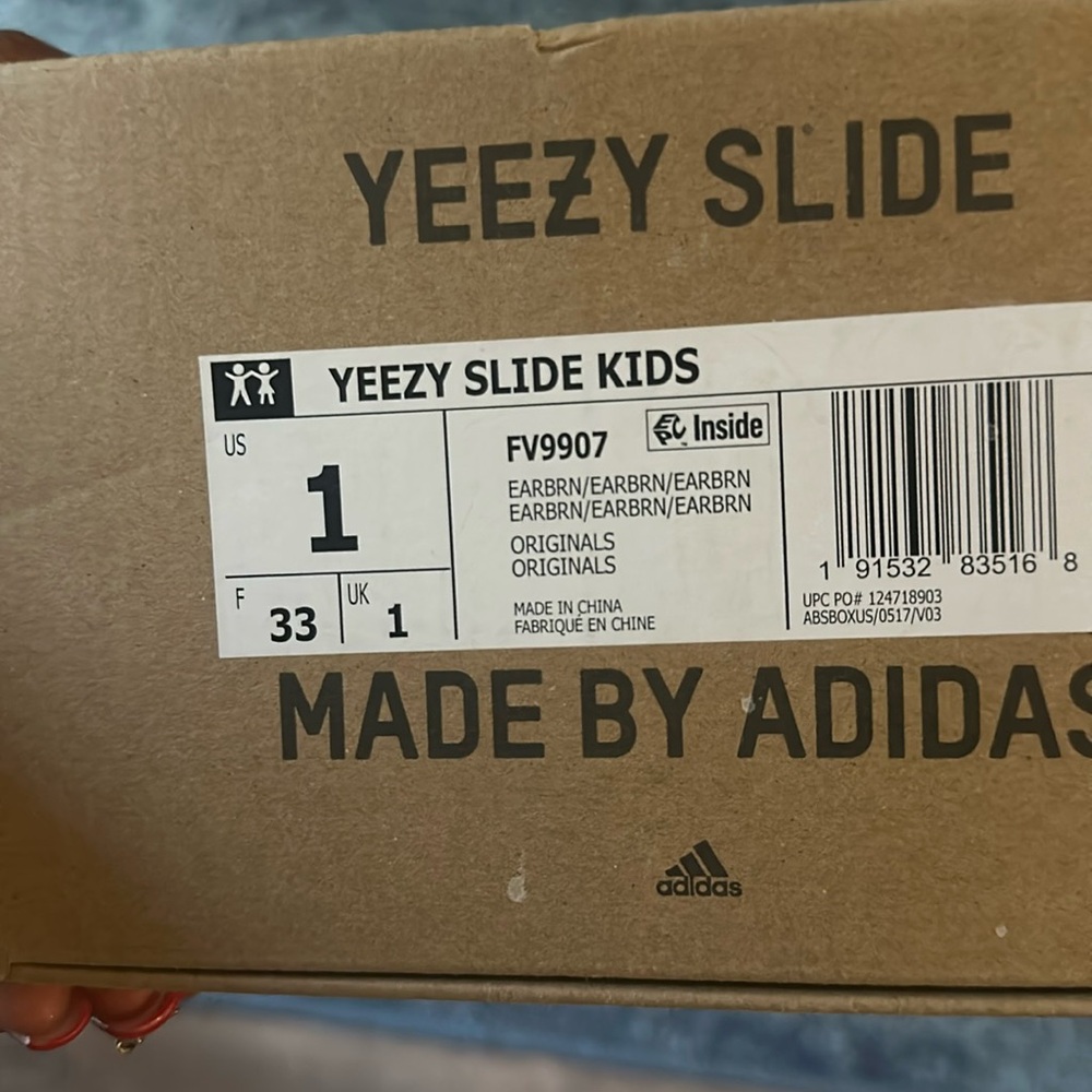 Cream kids Yeezy slides worn